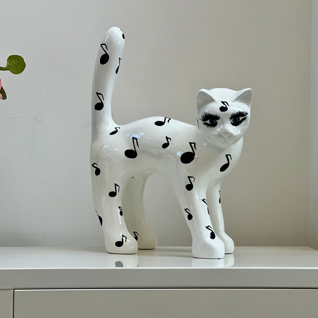 El Gato — Notas Musicales sobre un aparador en casa, foto real, 45 cm