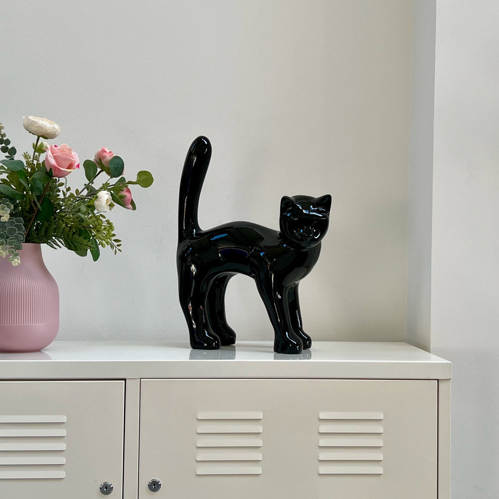 El Gato — Negro Tinta junto a un jarrón de rosas, para apreciar su tamaño real